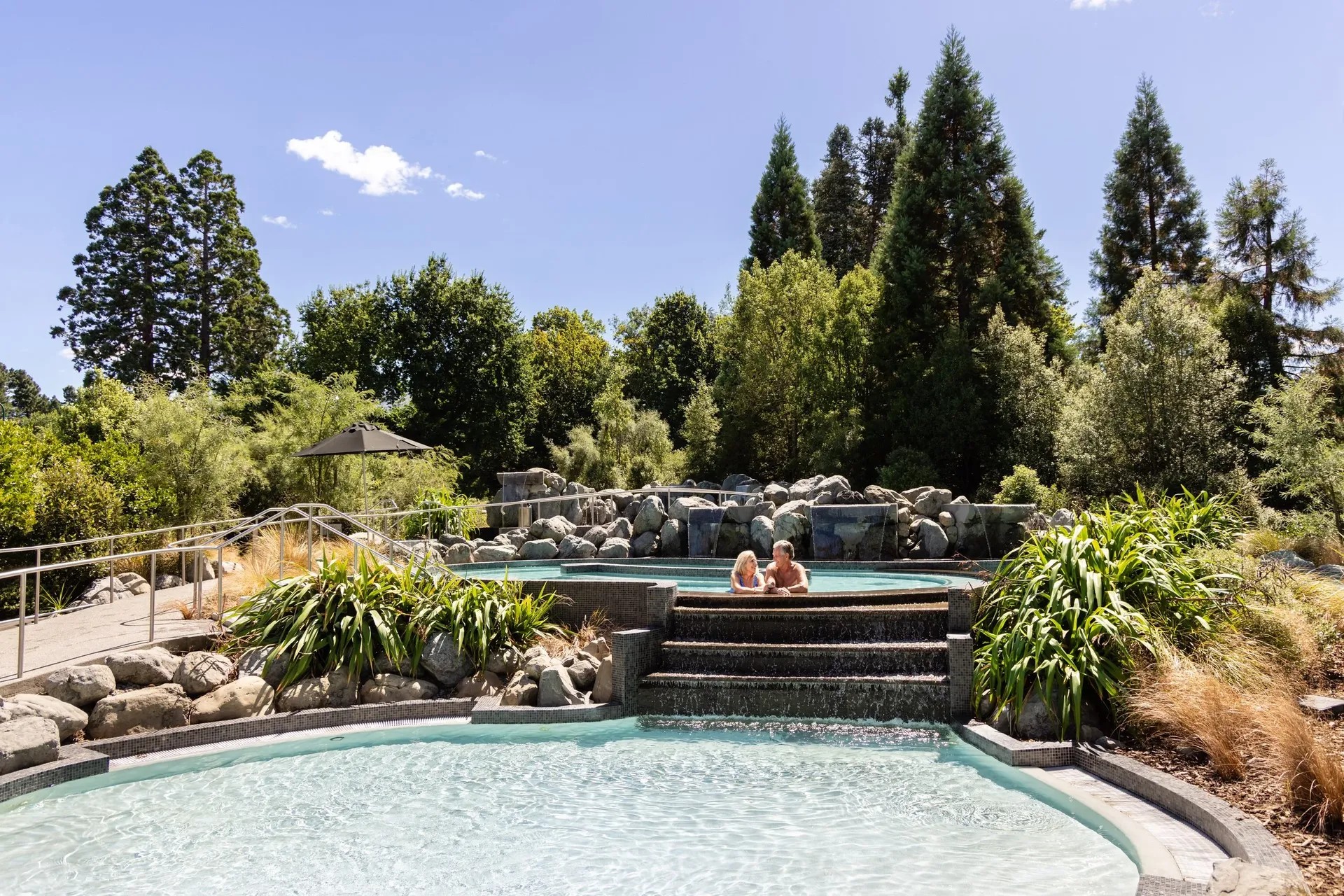 A couple relaxing in a two-tiered outdoor spa pool.