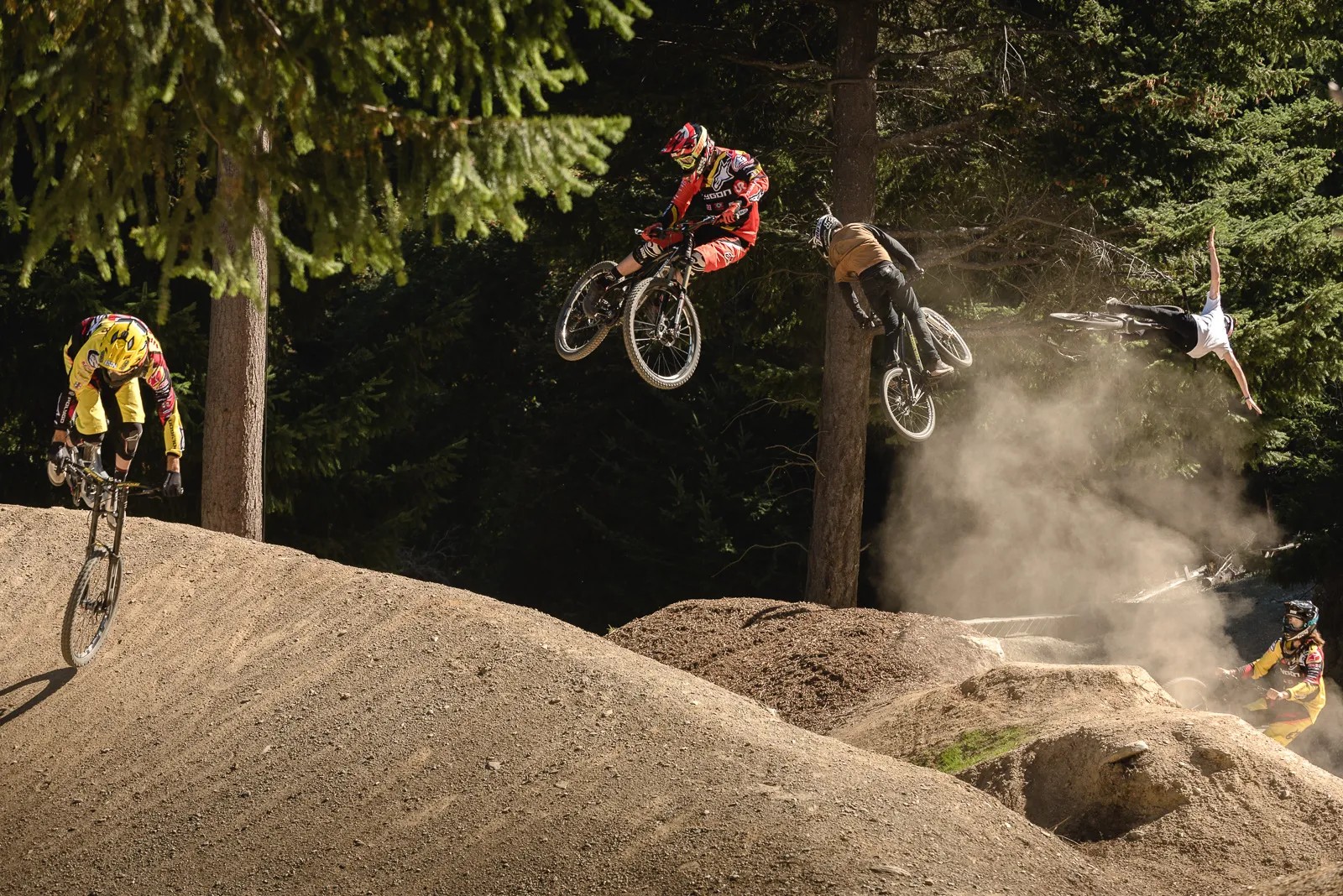 Bikers performing aerial tricks at a bike park.