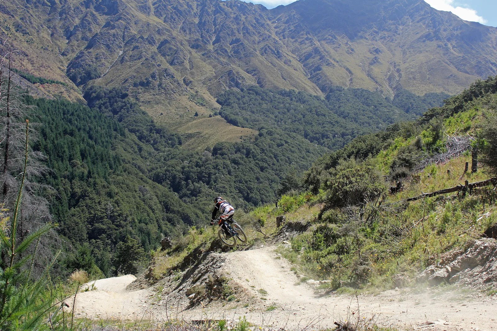 Biker riding on a dirt path in the mountains.