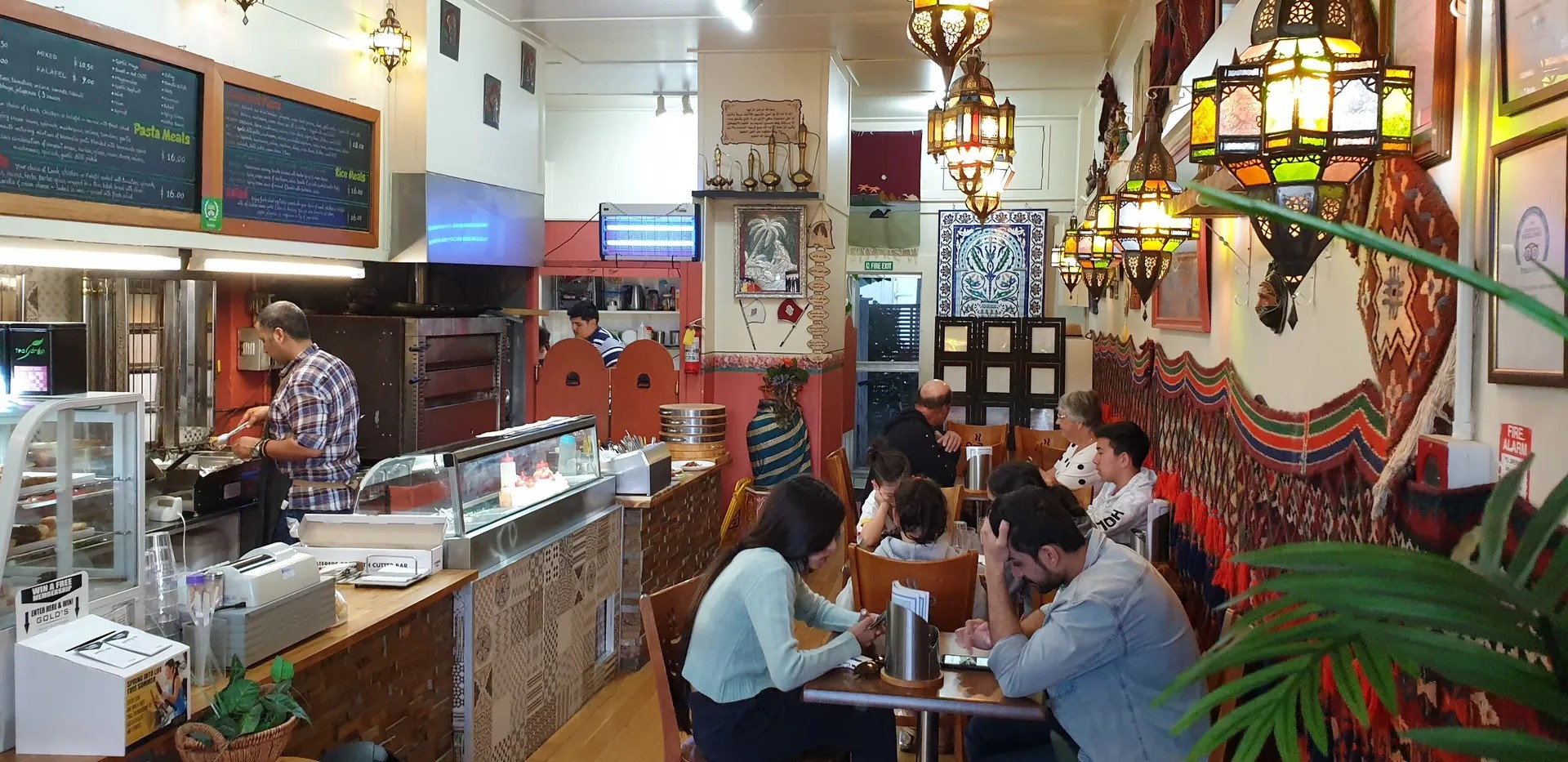 Small diner with Middle Eastern wall decor and lighting.