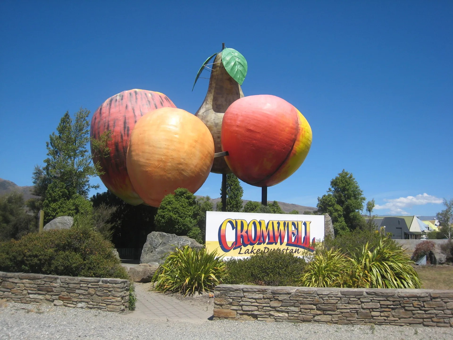 Giant nectarine, pear, apple, and apricot sculpture above a sign for Cromwell.