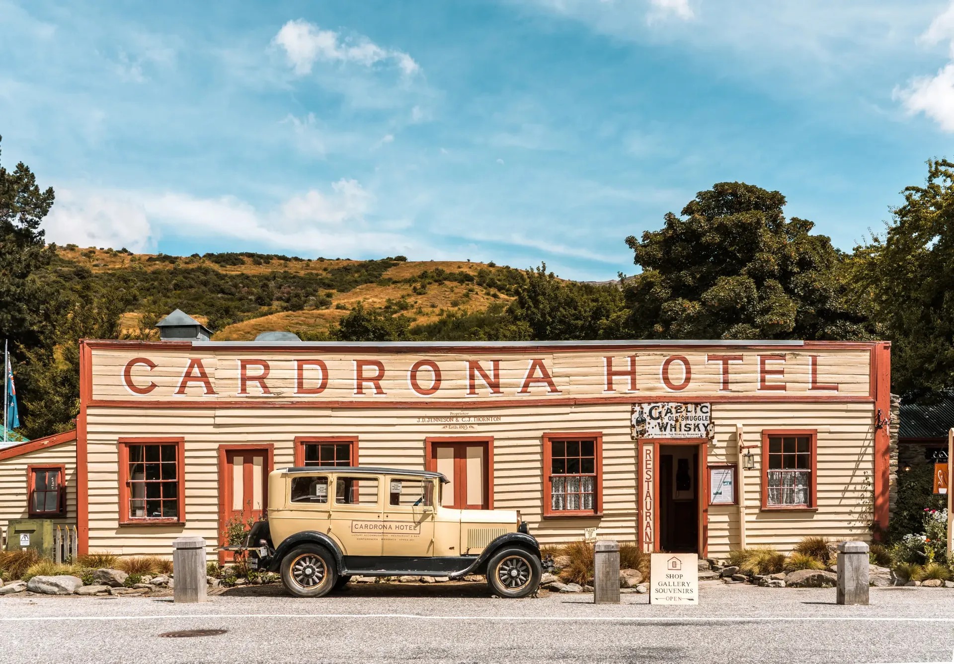 Old, rectangular building with an antique car in front.