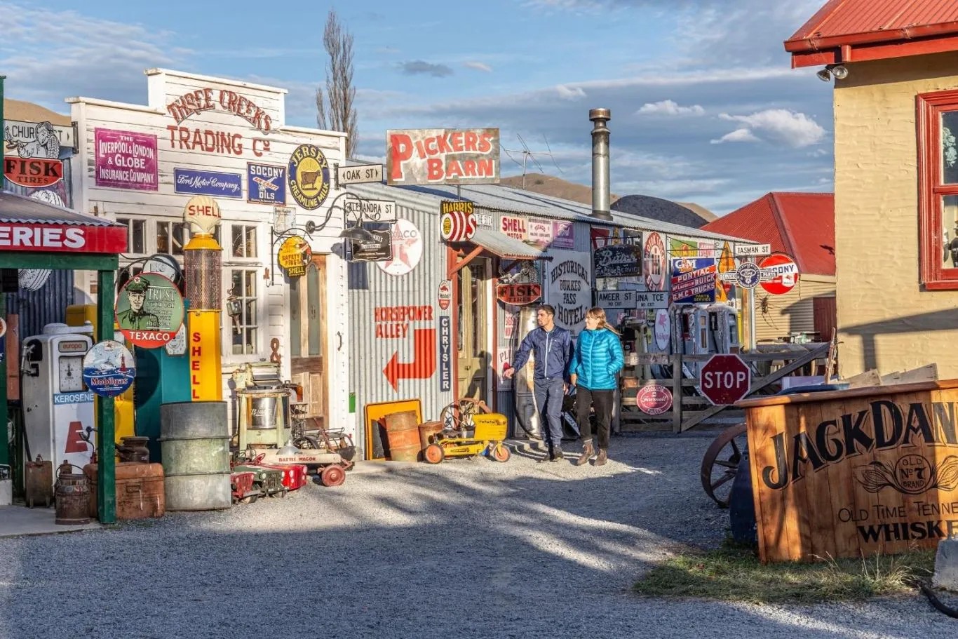 Couple strolling through a town with vintage buildings covered in signs.