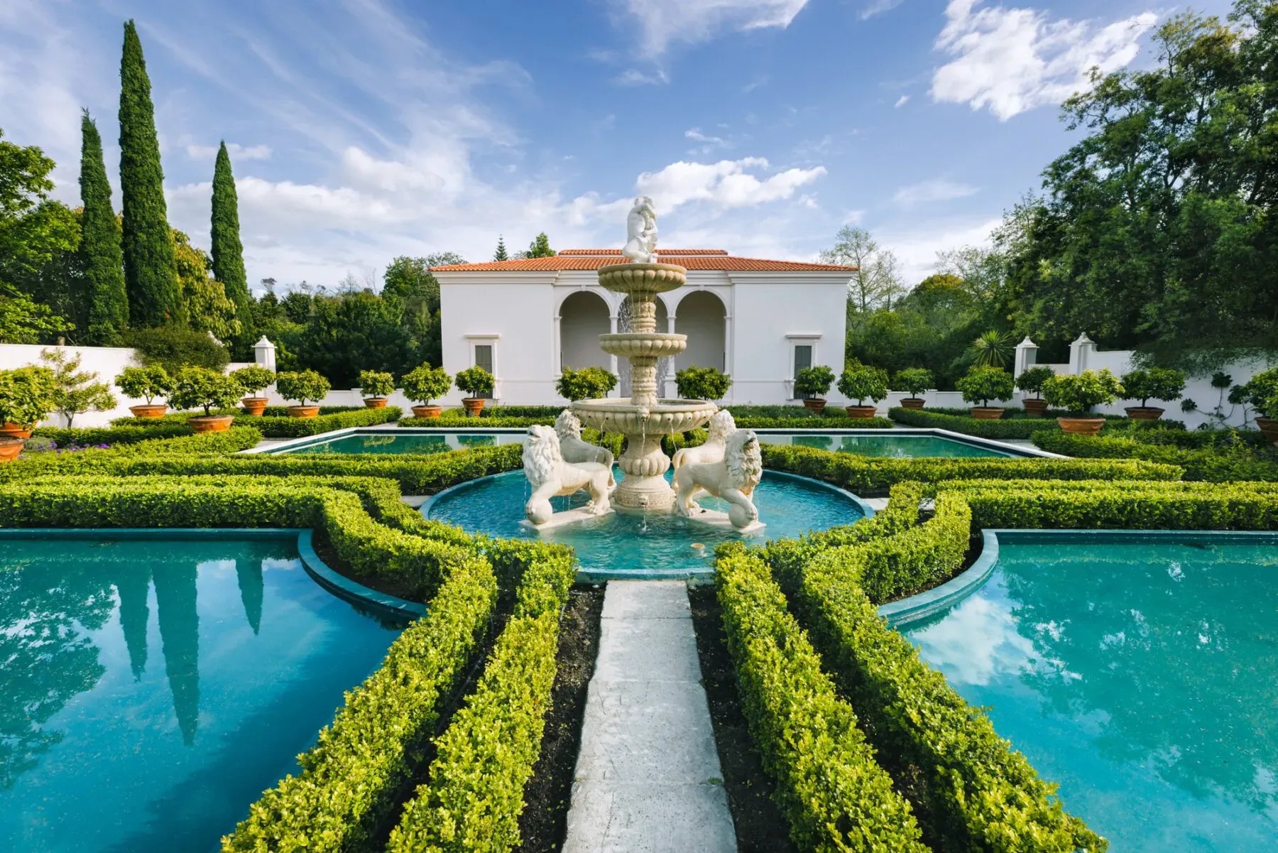 Recreation of a historical Italian garden with hedge patterns, shallow pools, and a centre fountain with lions.