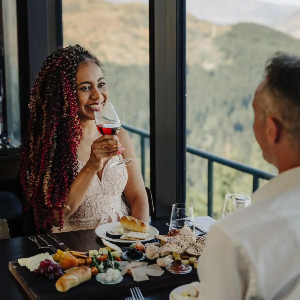Couple enjoying wine and shared platter dining at Skyline Stratosfare Restaurant with scenic views