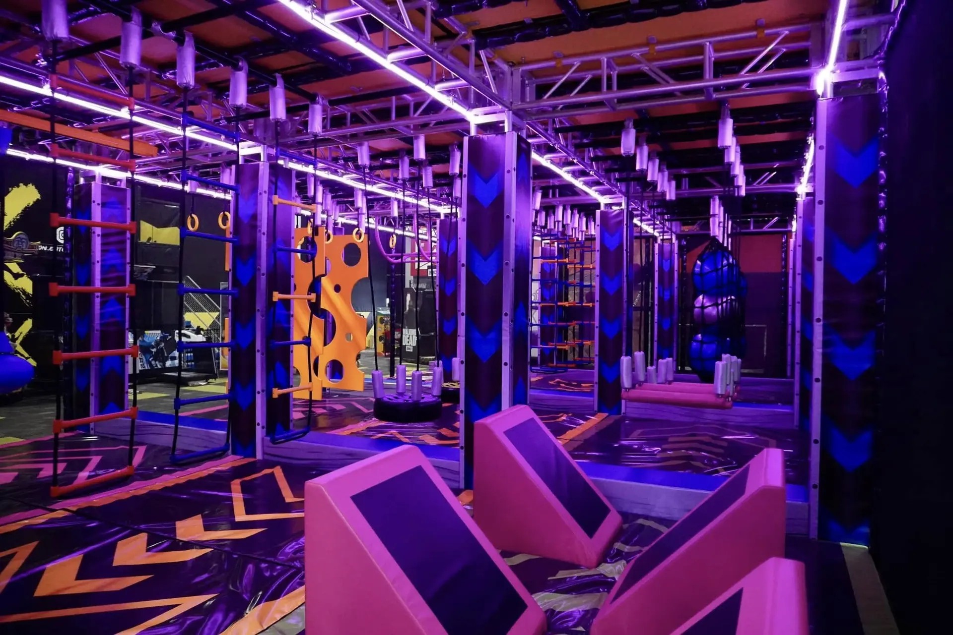 An indoor children's play park lit by neon lights.
