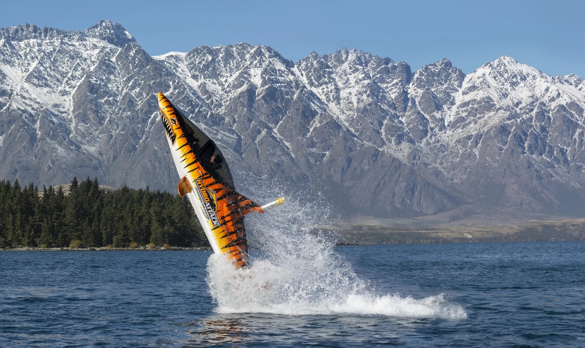 Submarine-type vehicle shaped like a tiger shark jumping out of Lake Wakatipu at a 70 degree angle.