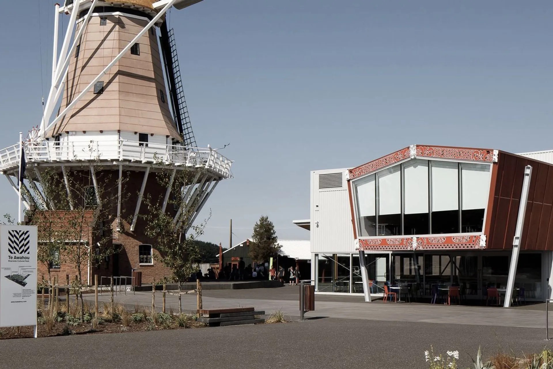 Dutch windmill next to a contemporary museum building inspired by Maori design.