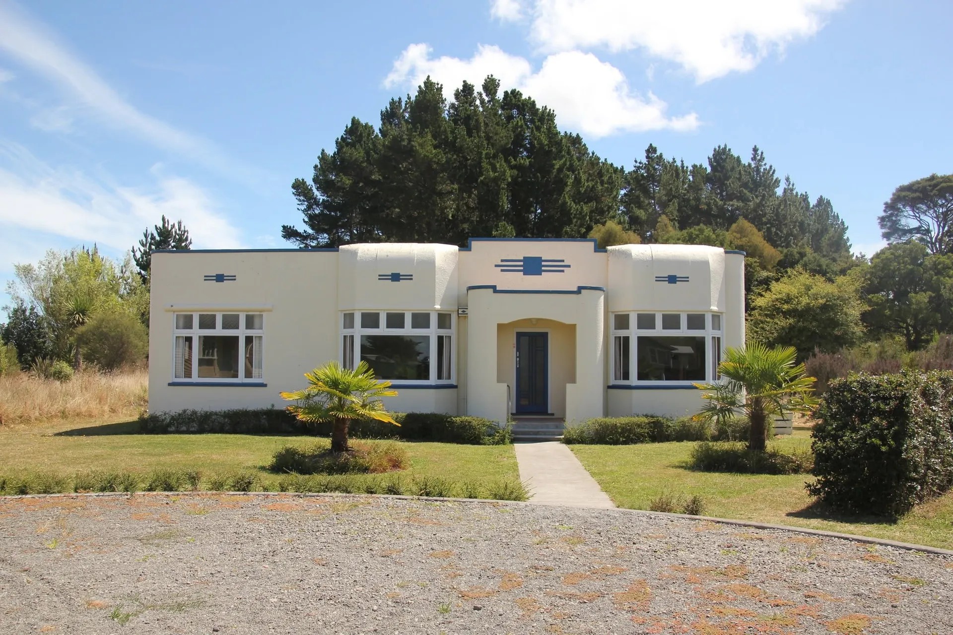 1930s moderne style house. Squareish design with white base and blue accents.